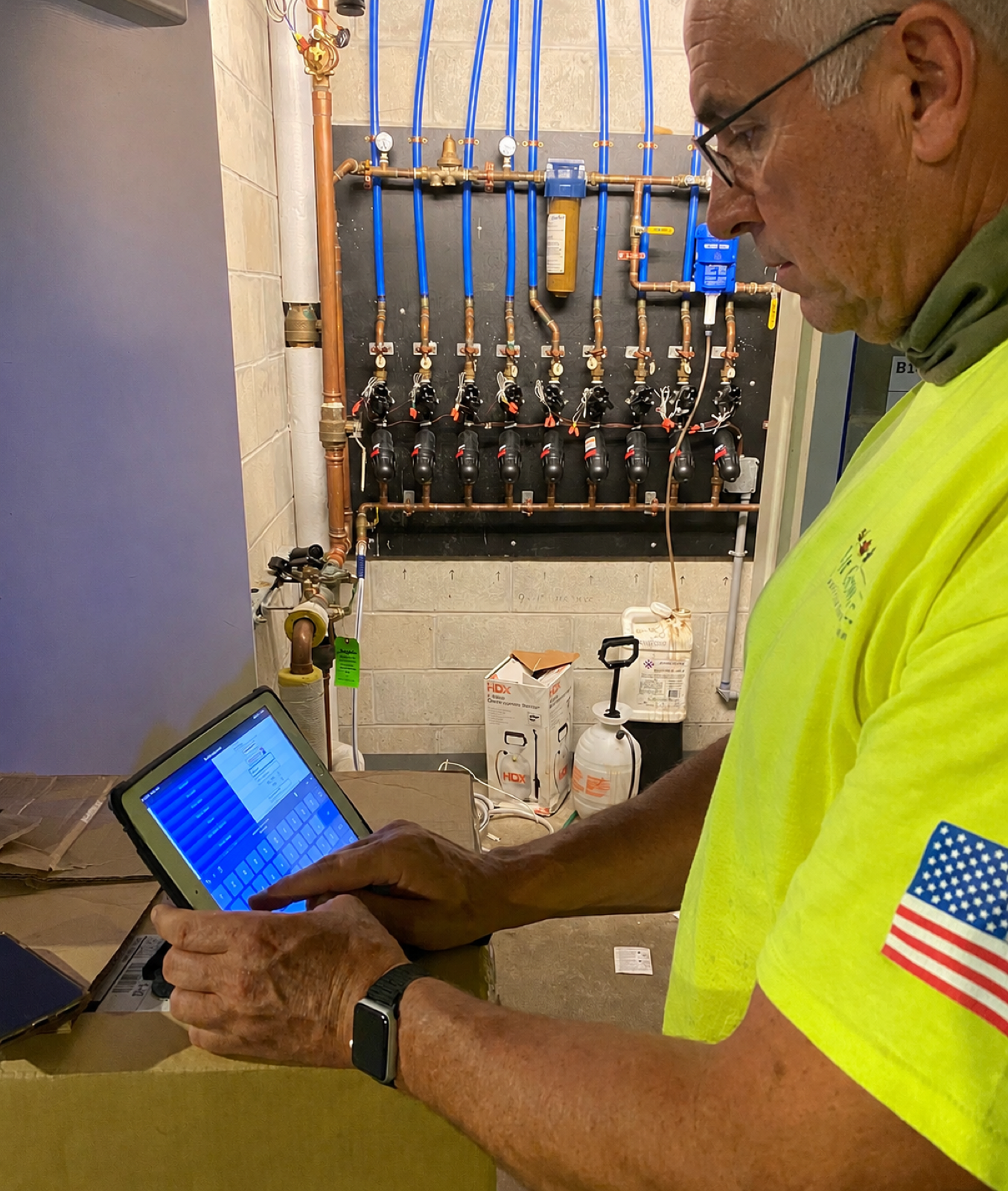 Technician using a tablet beside irrigation control hardware
